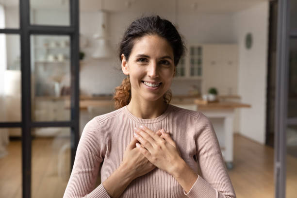 istock Grateful millennial latin woman hold hands on chest express appreciation 1313653347