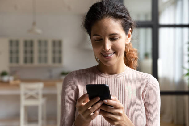 istock Happy young lady read good message on phone at home 1313653370