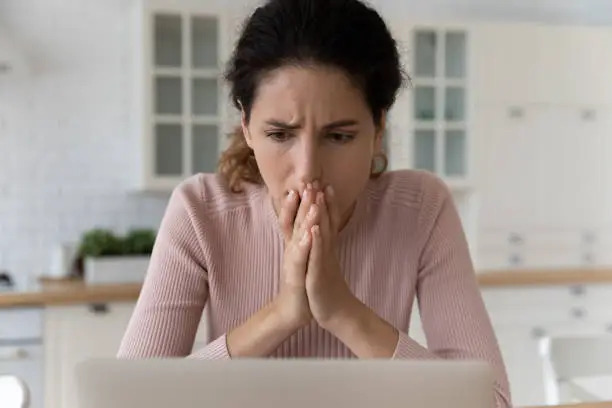 Photo of Shocked hispanic female read unexpected bad news on pc screen