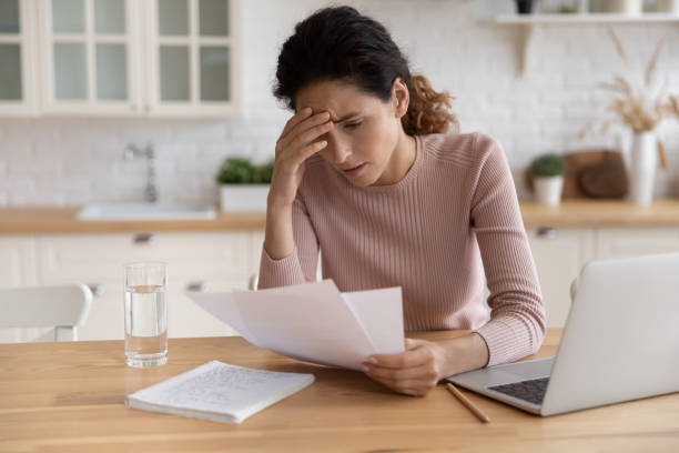 Stressed millennial female think on bank notification about business bankruptcy Worried stressed millennial female freelancer scratch forehead think on bank notification about business bankruptcy tax loan mortgage debt. Unhappy latin woman concern about bad news in paper letter exam paper stock pictures, royalty-free photos & images