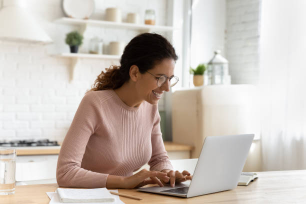 istock Happy smiling latin female writer in glasses typing on pc 1313653706