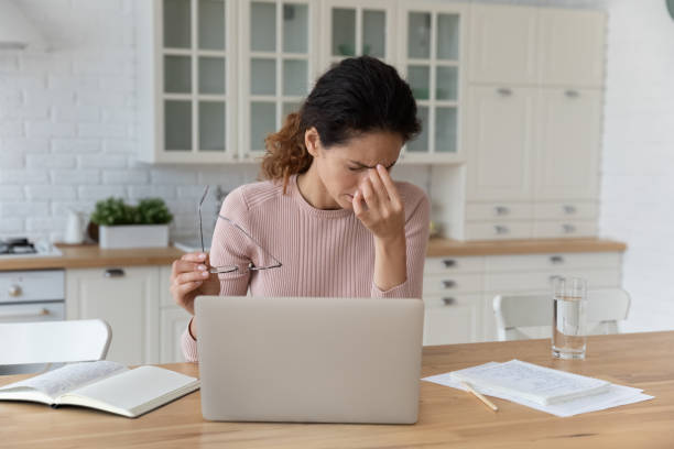 istock Tired young latin female distracted from laptop rub nose bridge 1313653762