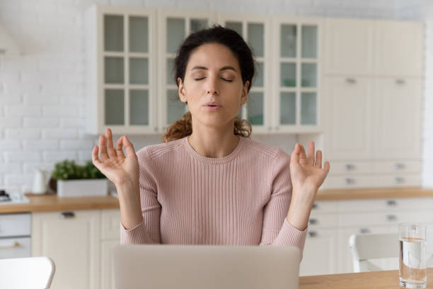 Calm hispanic female sit by pc with closed eyes meditate Home office yoga. Calm millennial hispanic female freelancer sit by pc with closed eyes breath deep meditate. Mindful young woman relax from online work doing breathing exercises join fingers in mudra breathing exercise photos stock pictures, royalty-free photos & images