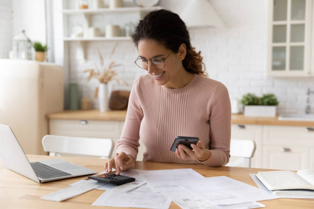 istock Young latina female work with financial papers count on calculator 1313653774