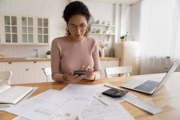 istock Young hispanic female use modern phone laptop for home accounting 1313653794