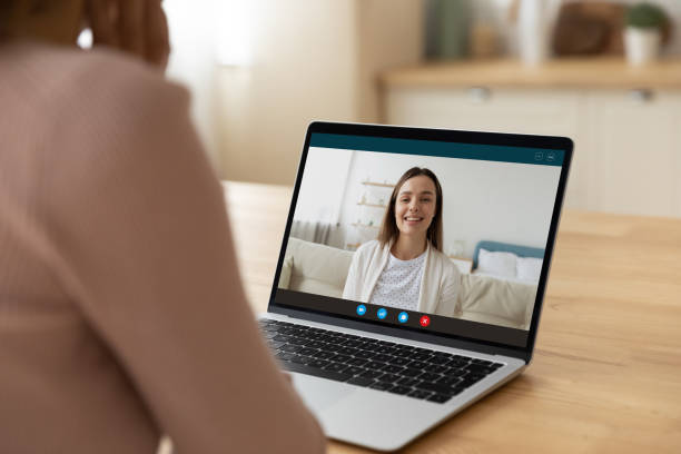 istock Rear view of female teacher talk to student using laptop 1313654582