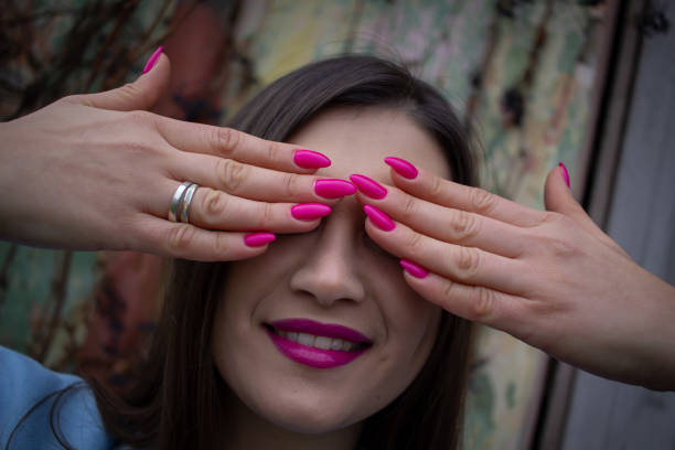 Macro shot of a woman's face with closed eyes and a hand covering part of it, expressing fatigue, pain, or emotional stress. The detailed image highlights human skin texture, expression, and emotion.