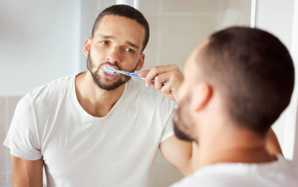 istock Shot of a young man brushing his teeth in his bathroom 1313656113