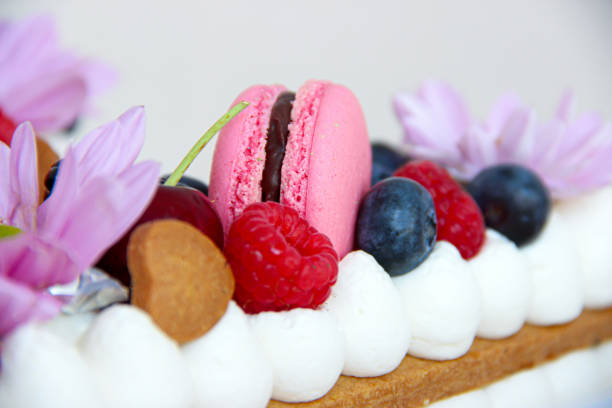 istock biscuit cake with cream, macarons and red berries 1313656385