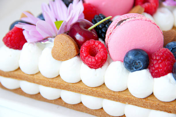 istock biscuit cake with cream, macarons and red berries 1313656516