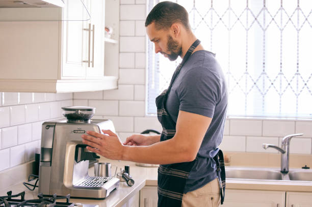istock Shot of a young man using a coffee machine to make himself a beverage 1313657710