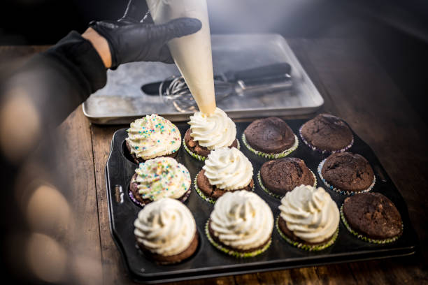 istock Close-up of hand decorating cake with whipped cream 1313659416