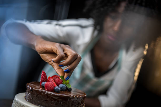 istock Woman placing mint leaf on chocolate cake 1313659501