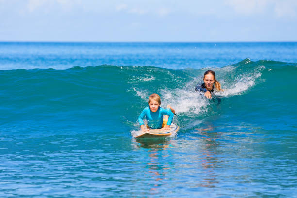 istock Young surfer learn to ride on surfboard with surf instructor 1313663122