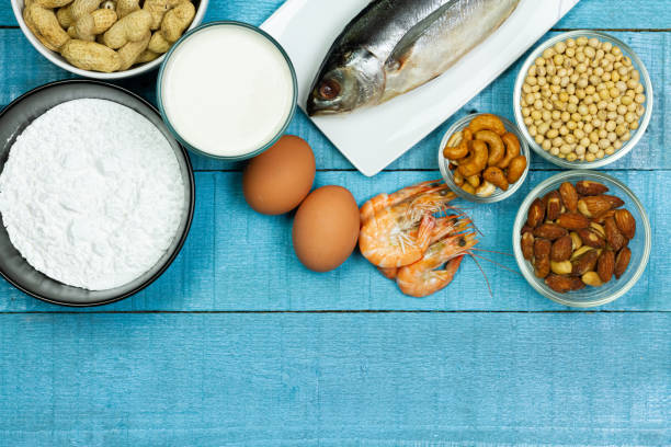 Major food allergens. Major food allergens include milk, egg, penuts, fish, shrimp, wheat flour, soya, almond and cashew nut on blue rustic wooden table, top view. Allergy food concept. food allergies stock pictures, royalty-free photos & images