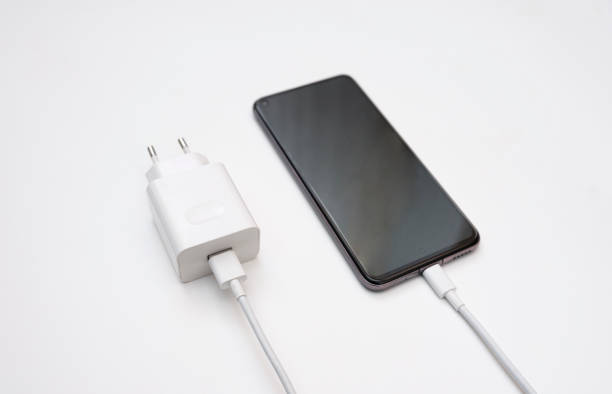 istock Charging a smartphone via a USB cable on a white background, top and side view. 1313666692