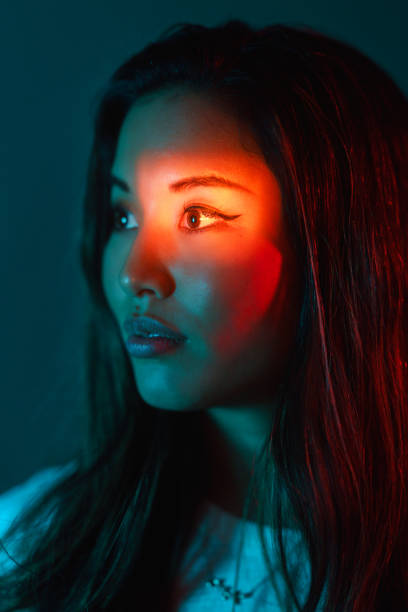 portrait of beautiful woman lit by neon colored lights - vertical bright brightly lit vibrant color imagens e fotografias de stock