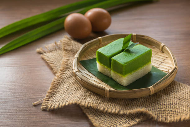Selective focus of Kuih Seri Muka, traditional Malaysian two layered dessert with steamed glutinous rice forming the bottom half and a green custard layer made with pandan juice. Selective focus of Kuih Seri Muka, traditional Malaysian two layered dessert with steamed glutinous rice forming the bottom half and a green custard layer made with pandan juice. traditional malaysian food stock pictures, royalty-free photos & images