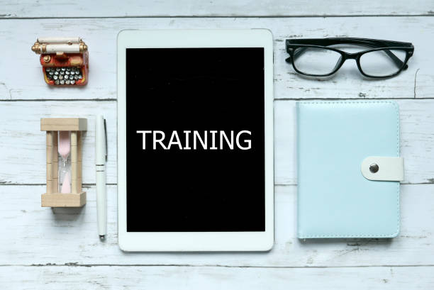 istock Training Mentoring Learning Education through online digital Concept. Top view of sand clock,notebook,pen,glasses and tablet written with Training on white wooden background. 1313672175