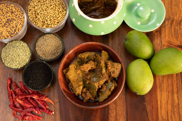 istock Mango pickle or Aam ka Achar top view with indian spices and chillies and raw mango isolated on wooden background 1313674036