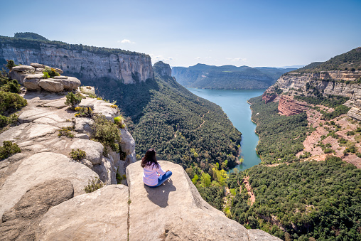 Tourist's  sitting looking in front of the Morro de l'abella mountain, in front of the Ter river, catalonia, Spain