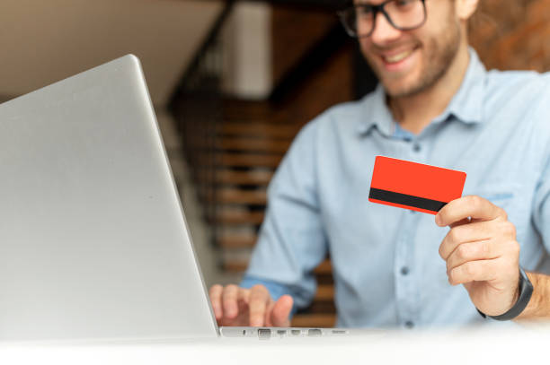 istock A guy holds credit card and using laptop 1313675647