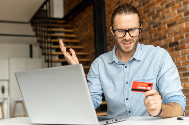 istock A guy holds credit card and using laptop 1313675684
