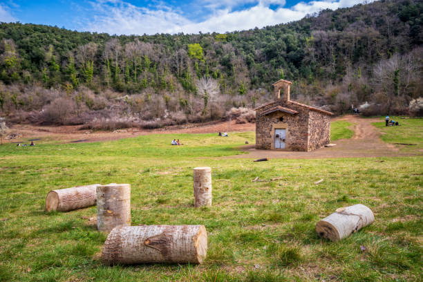 View of small logs in front of the Hermitage of Santa Margarida that is located in the middle of the crater of the Santa Margarida volcano in La Garrotxa, Girona, Catalonia.