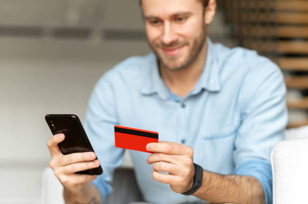 istock A guy holds credit card and using phone 1313677002