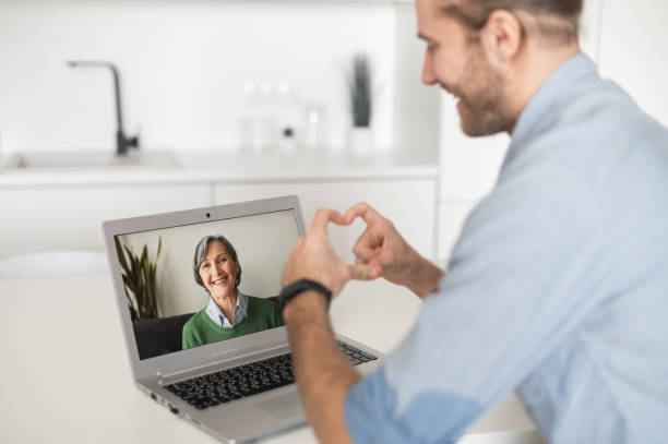 istock Young handsome guy talking to grandmother online 1313677156
