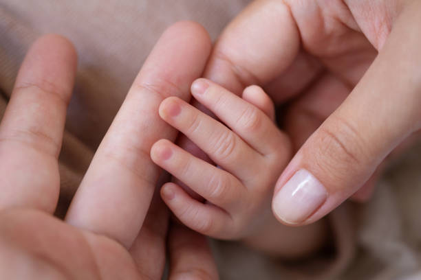 istock mother holding her baby hand 1313681247