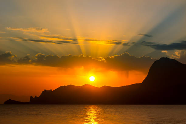 istock sunset over the mountains by the sea coast 1313681610