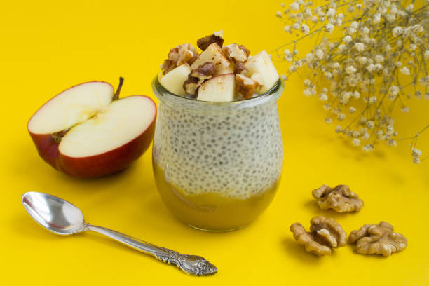 istock Pudding with chia seed, apples,cinnamon and walnuts on the yellow  background. Close-up. 1313683777