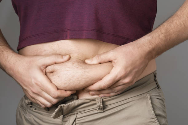 istock The man shows problems with overweight in the abdomen 1313686989