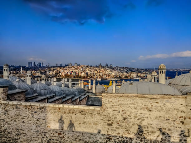 vue de la région de karakoy et des dômes du musée suleymaniye salis medresesi depuis le pont d’observation de la mosquée suleymaniye à istanbul (turquie). ombres des personnes sur le vieux mur - istanbul surrounding wall suleymanie mosque turkey photos et images de collection