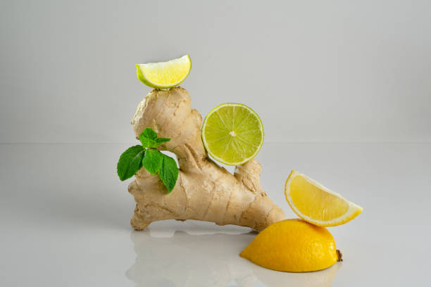 istock Summer refreshment, cocktail or tea recipe. Lemon slice, lime, ginger and mint leaf on grey background. 1313687928