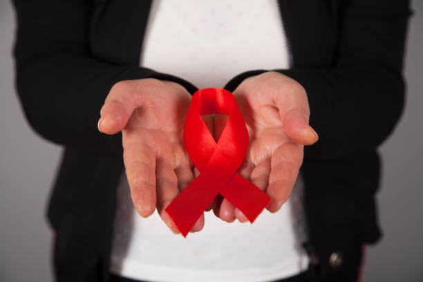 istock Woman's hands holding red AIDS awareness ribbon. 1313687947