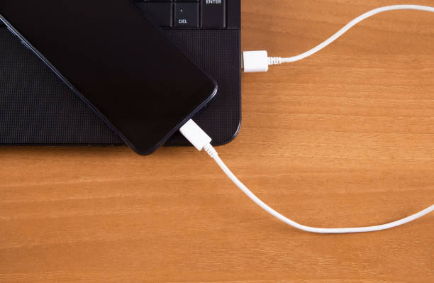 istock Wooden background isolated charger, smartphone and computer. 1313688010