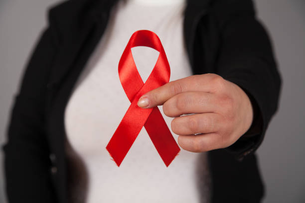 istock Woman's hands holding red AIDS awareness ribbon. 1313688014