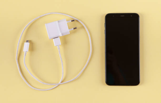 istock Mobile smartphone with charging on yellow background. 1313688105