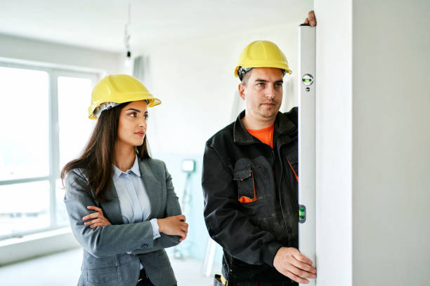 istock Woman architect interior designer and foreman working together with tiles samples discussing the project for interior decoration in building site 1313688219