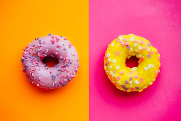 istock Two sugar glazed donuts on colorful background. 1313688234