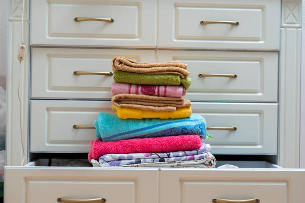 stack of new clean fresh color towels textile on the shelf in laundry
