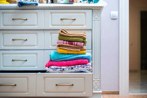 stack of new clean fresh color towels textile on the shelf in laundry