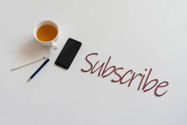Photo of follow of subsctribe title, flat lay of digital device on the table