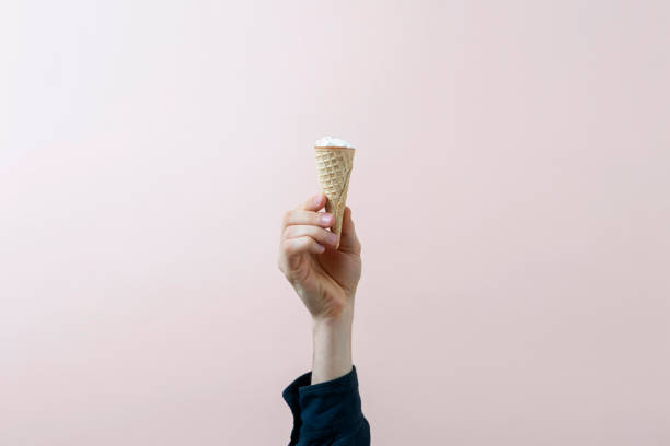 istock human hand holding ice cream cone isolated on color pastel background, abstract creative idea 1313689809