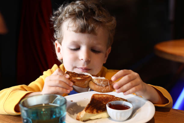 istock Boy eating a grilled cheese sandwich in a restaurant 1313690970