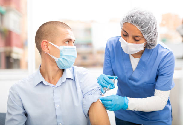 istock doctor in a protective face mask makes vaccination 1313691036