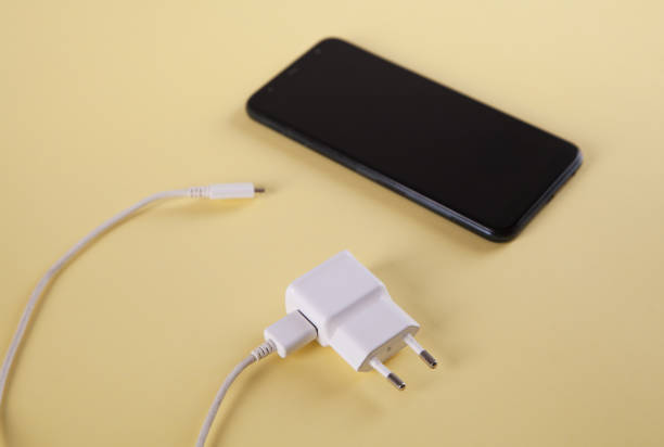 istock Mobile smartphone with charging on yellow background. 1313691107