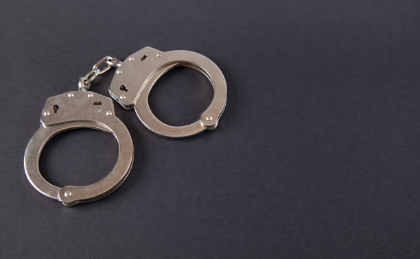 istock Metal handcuffs on an isolated black background. 1313691164